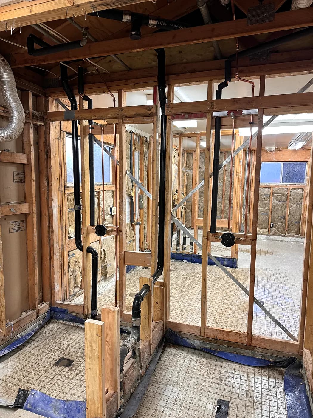 New pipes in the open framing of a commercial restroom area