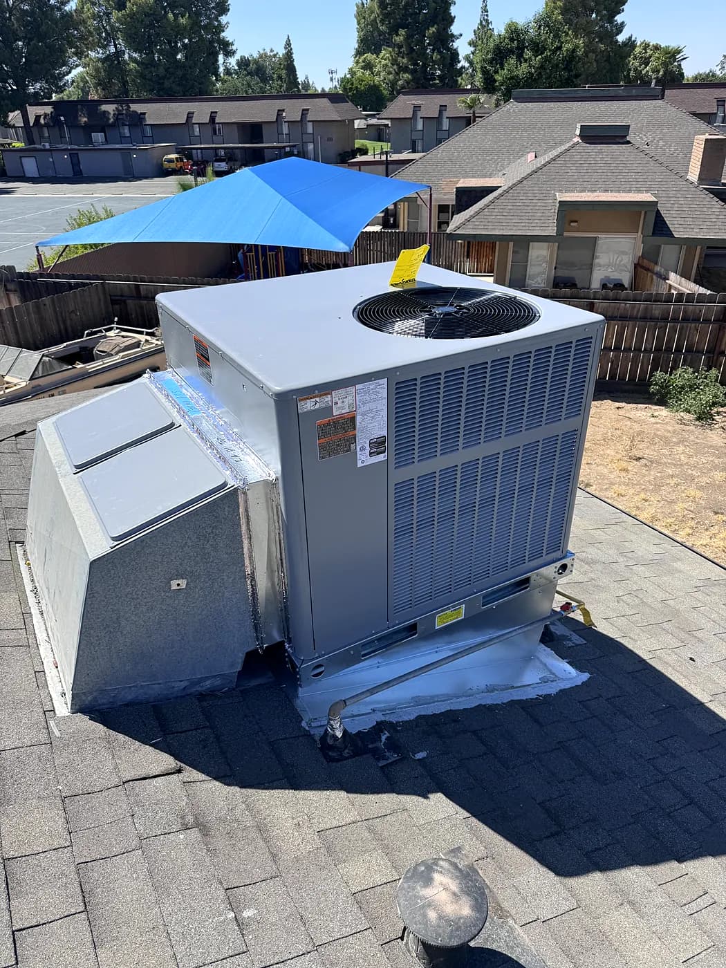 A new packaged air conditioning unit installed on a paved pad