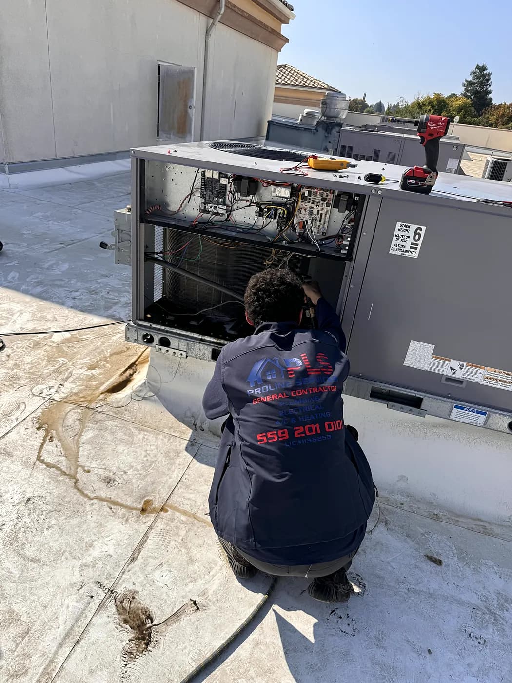 A ProLine technician servicing a rooftop AC unit