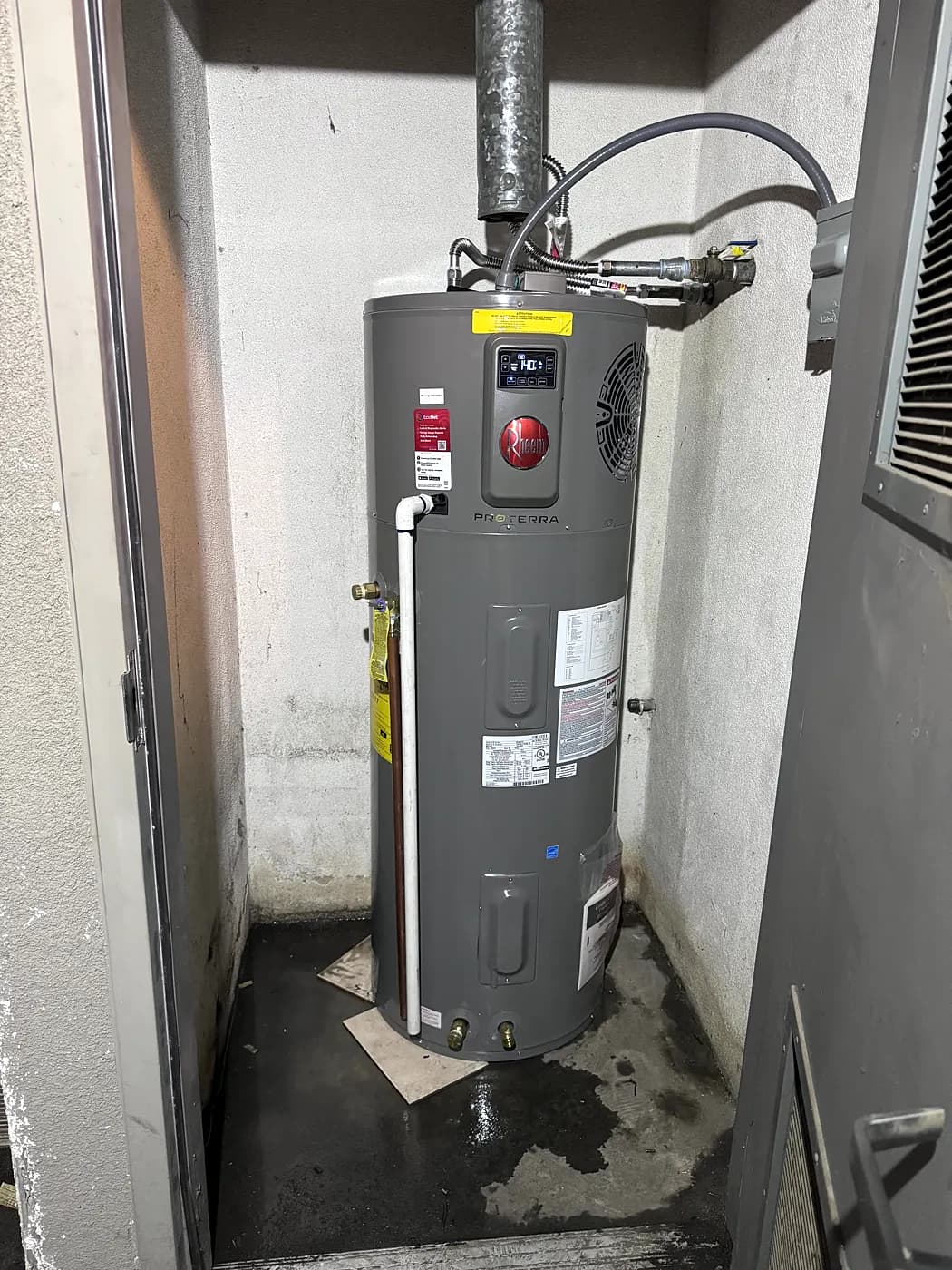 A new water heater installed in a narrow utility closet