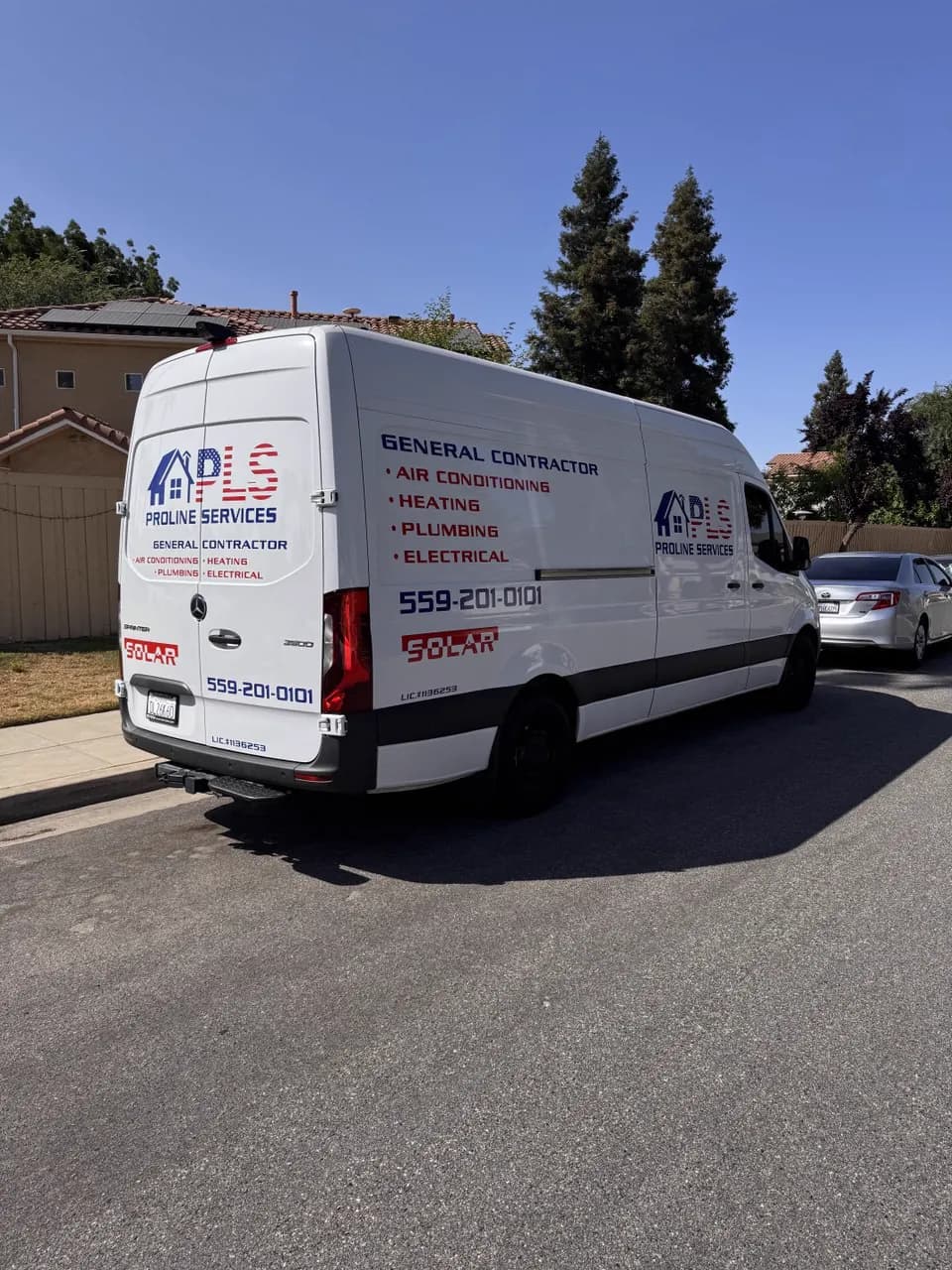 ProLine Services work van with its logo, trade list and phone number, parked on a residential street